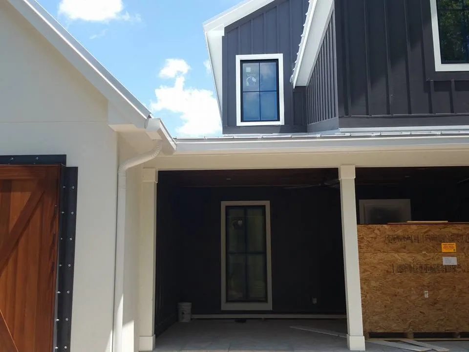 Covered breezeway white gutter downspout dark siding, Longwood